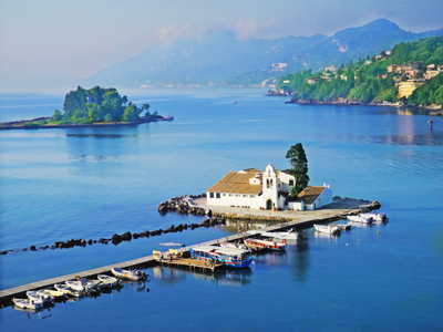 Klooster op het eilandje Pontikonisi bij Corfu, met aanlegsteiger en boten in de baai.