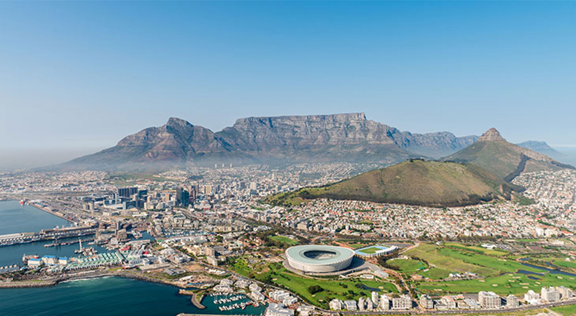 Uitzicht op Kaapstad en Tafelberg. Panorama van Kaapstad met de Tafelberg, Lion’s Head en het Cape Town Stadium aan de kust.