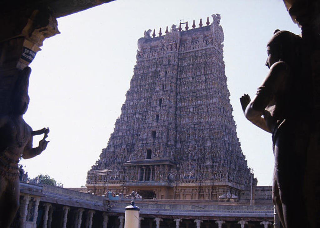 Hindoetempel met hoge gopuram, gezien vanaf een poort met beelden, tijdens groepsrondreis Zuid-India.