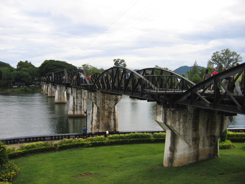 De Brug over de rivier Kwai bij Kanchanaburi, Thailand, met wandelaars op de spoorbrug.